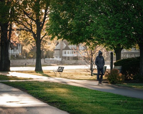 A person enjoying a relaxed morning walk in an Indian neighborhood park